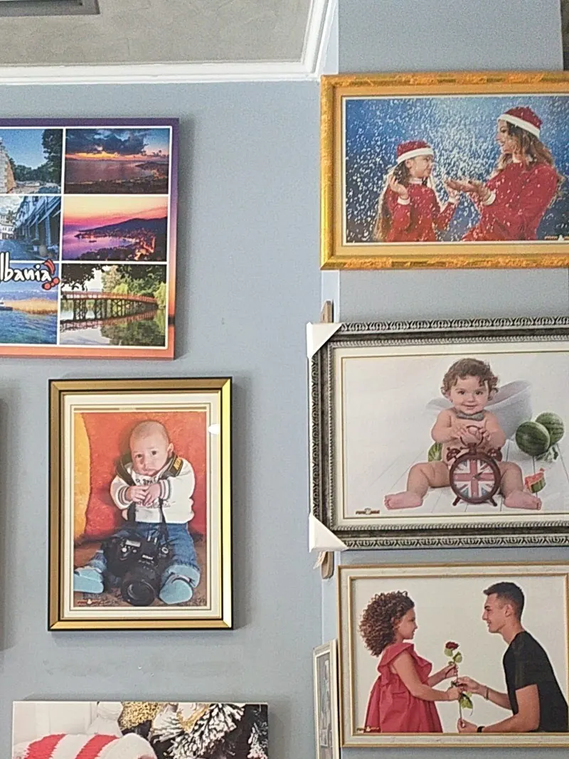 Framed portraits of couples and children hanging in the studio