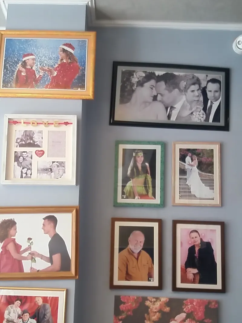 Framed wedding and family portraits on the studio wall